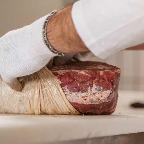 insaccamento della carne durante la preparazione del capocollo pugliese